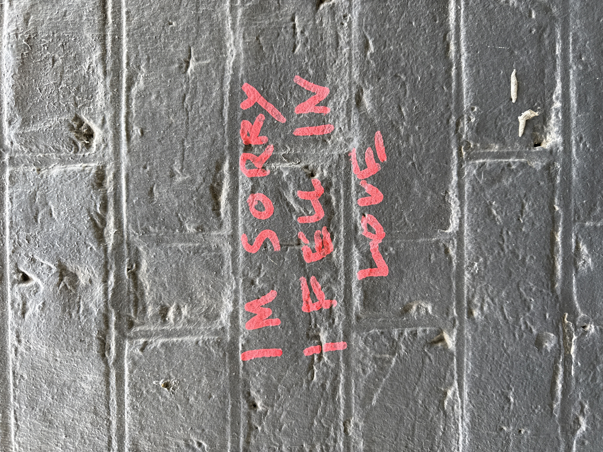 Love apology graffiti spotted on London brick wall