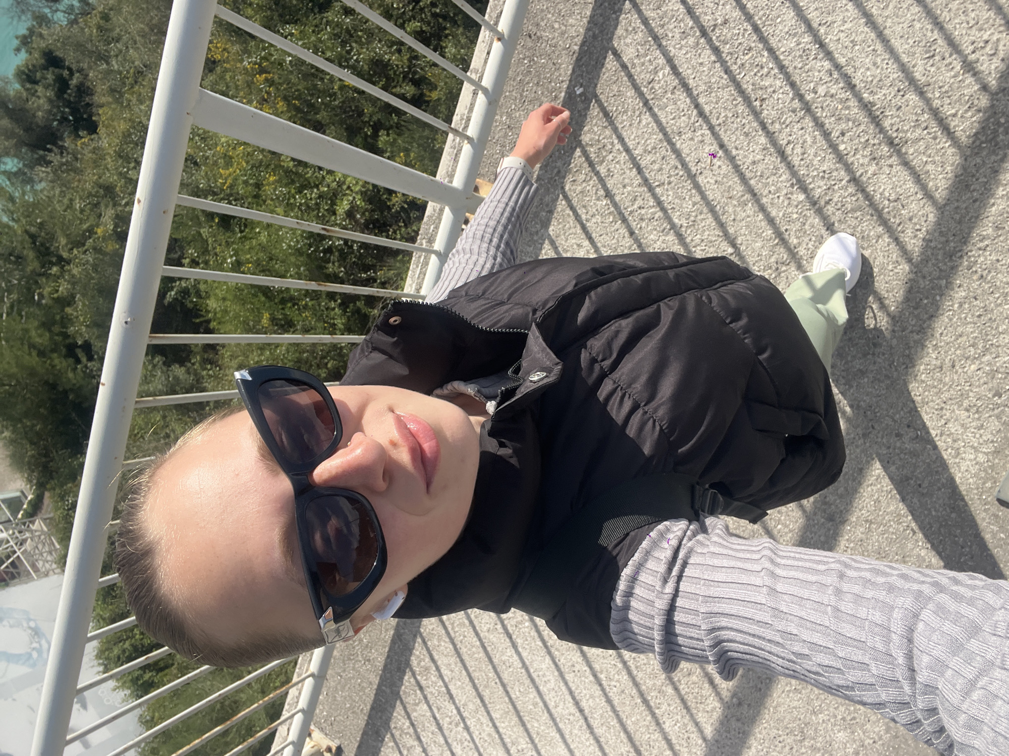 Tourist captures selfie on Budva footbridge amid coastal scenery