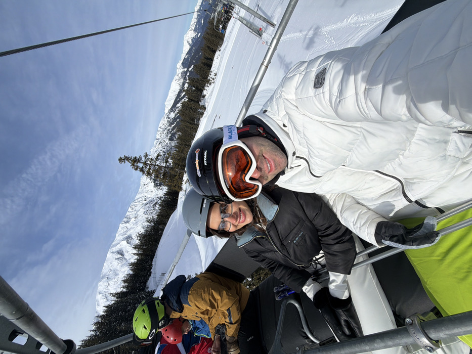 Skiers ride chairlifts at Les Allues resort under clear skies