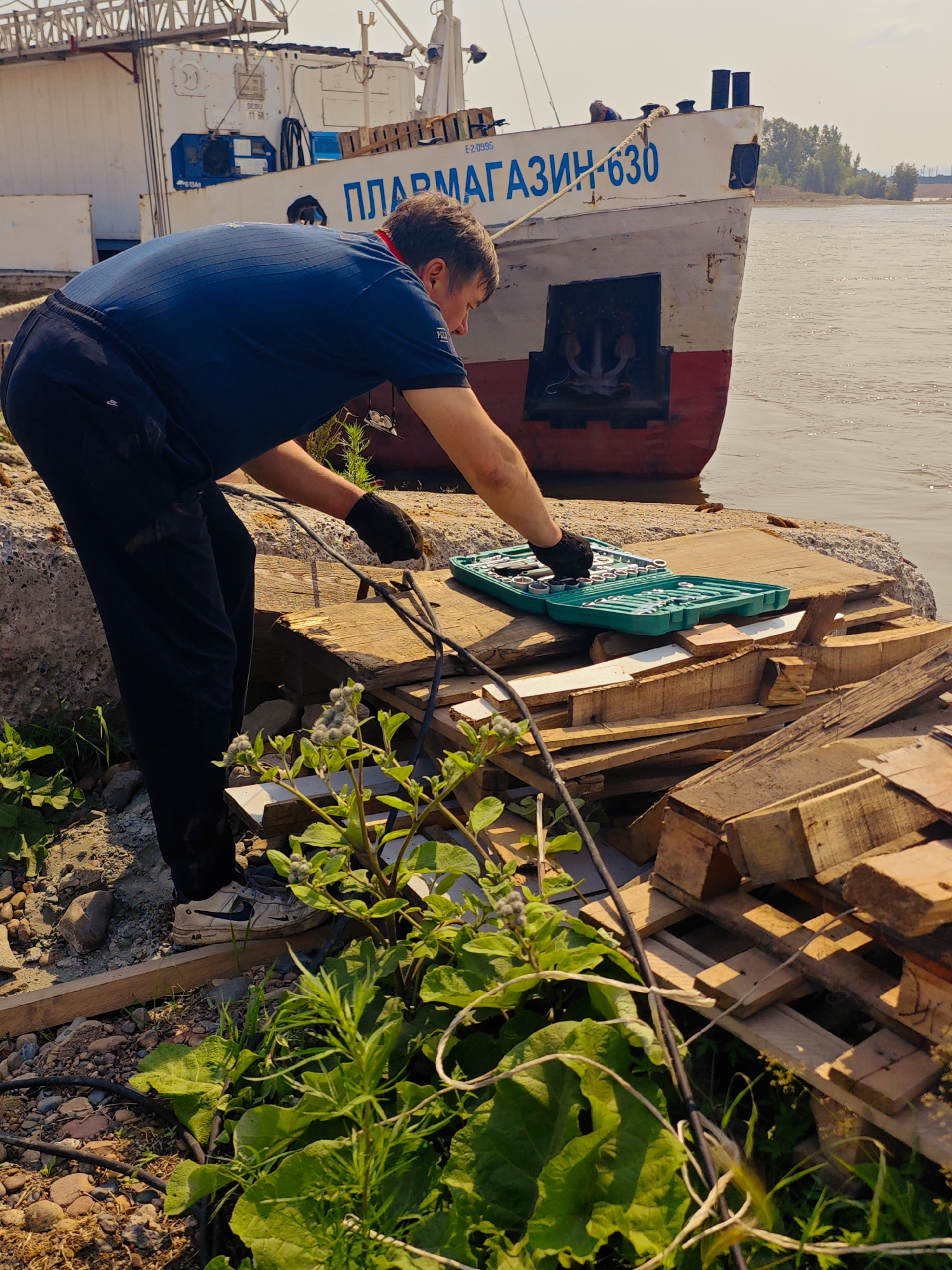 River dock crews unload pontoons and cargo in Krasnoyarsk
