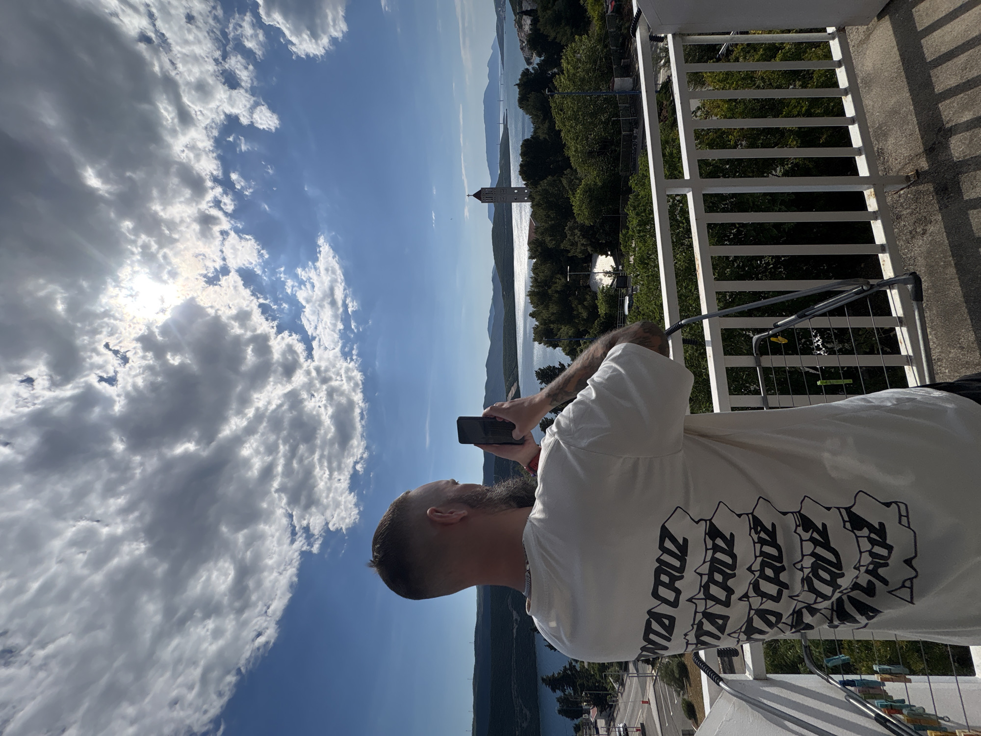 Tourist photographs coastal scenery from balcony in Neum