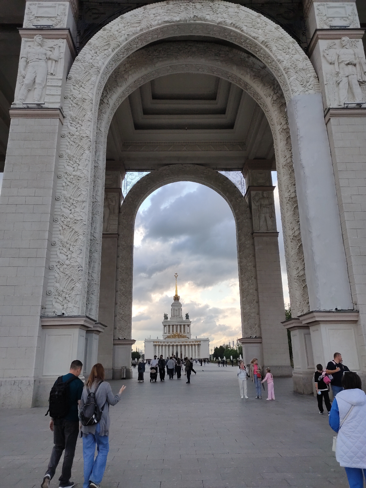 Ornate archway, fountain, and cherry trees at a grand public landmark