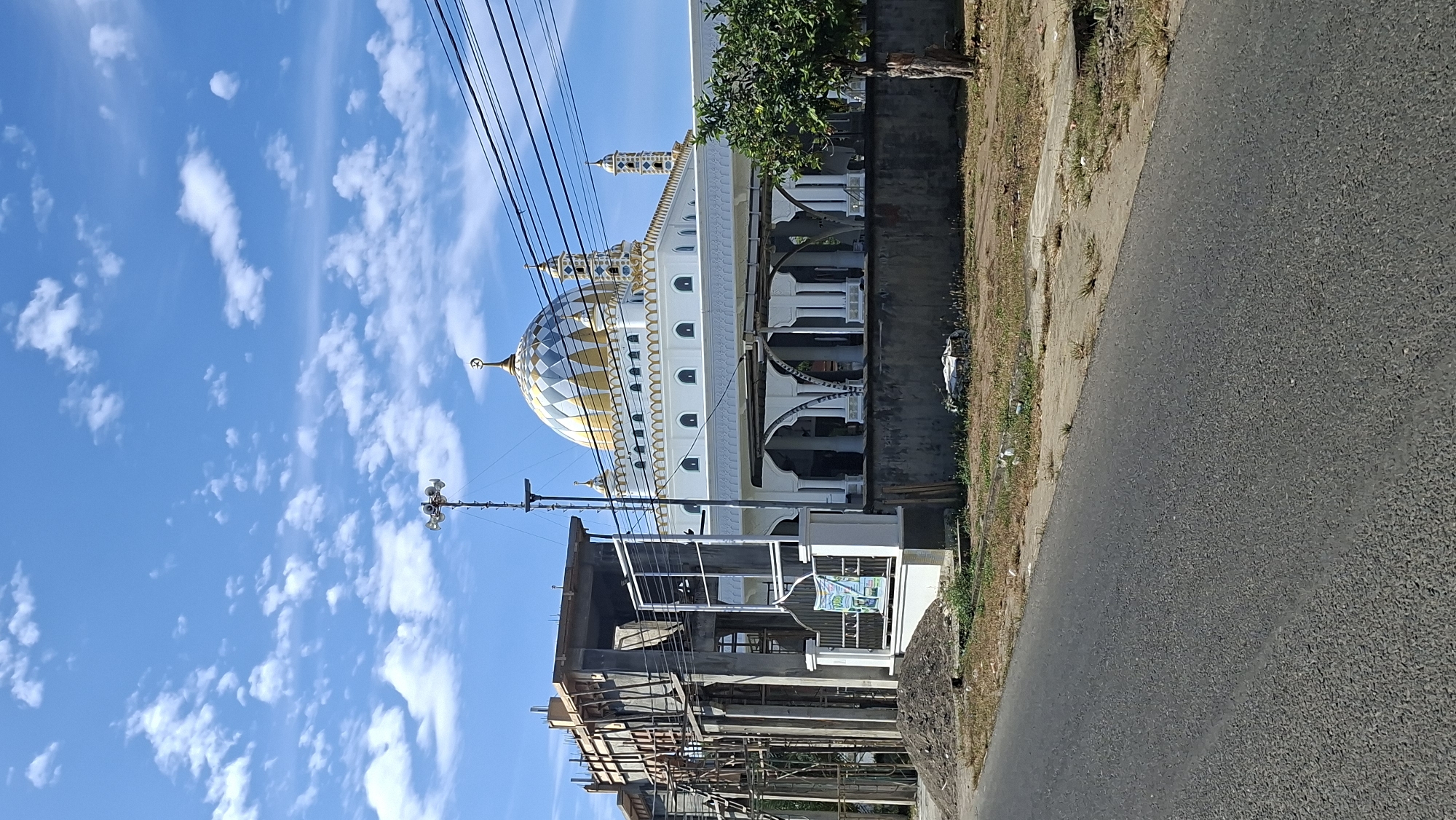 Hazy morning in Lhokseumawe — mosque, construction, and street life
