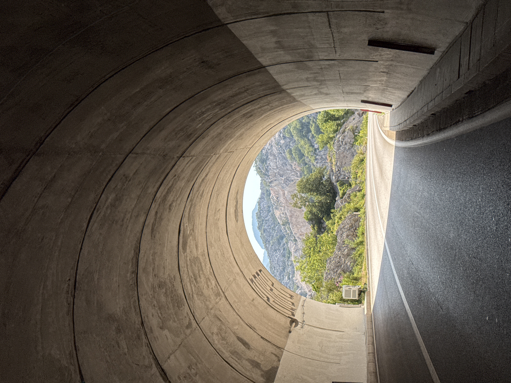 Tunnel exit opens onto rocky, green mountains near Risan