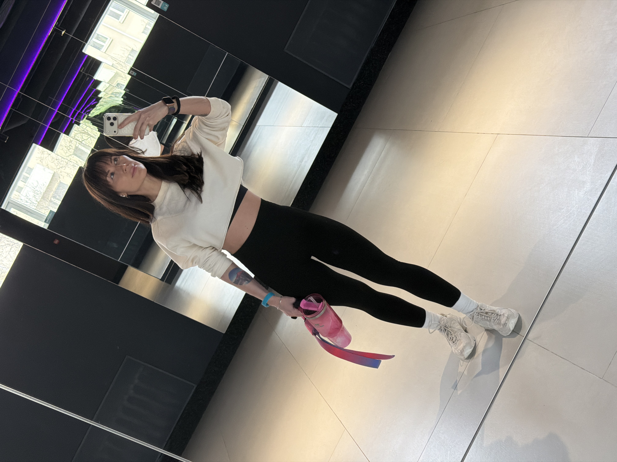 Woman takes mirror selfie with water bottle in Perm