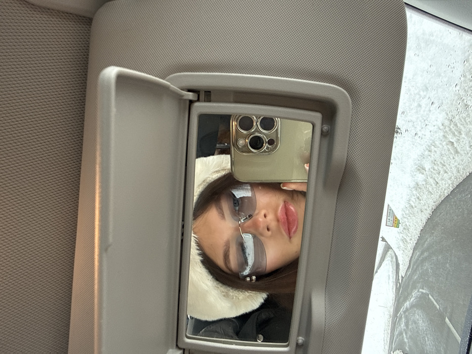 Woman takes vanity mirror selfie in Courchevel vehicle