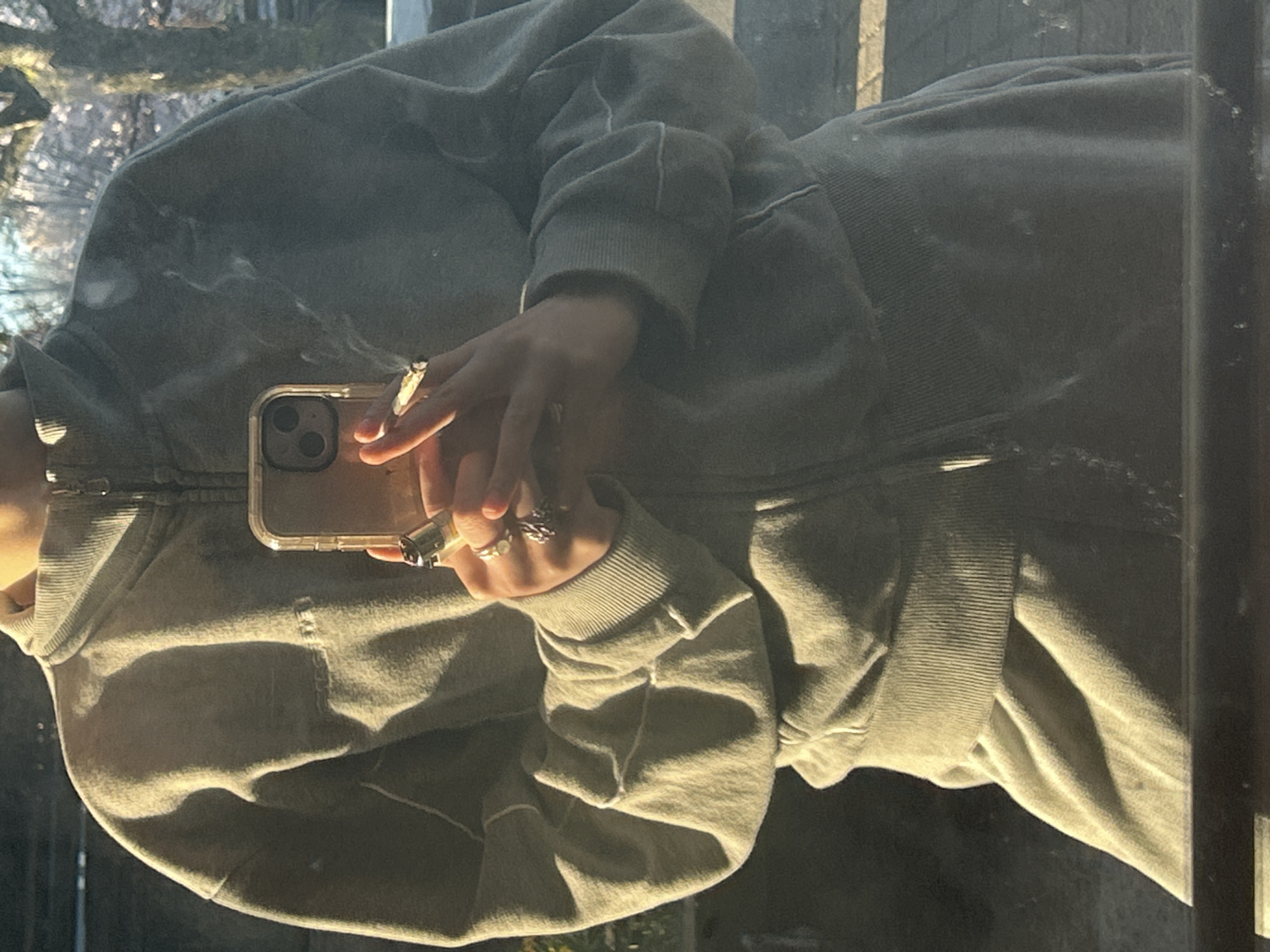 Woman smoking, using phone captured in Vancouver reflections