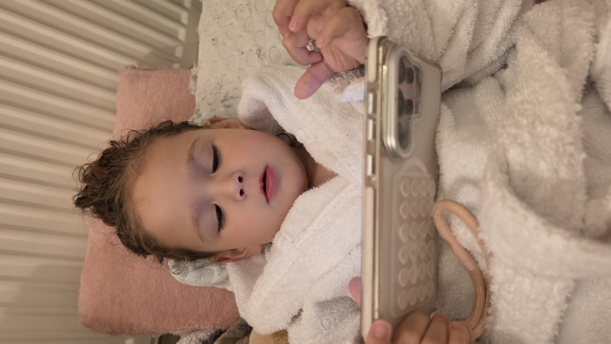 Child rests with smartphone before sleeping in London home