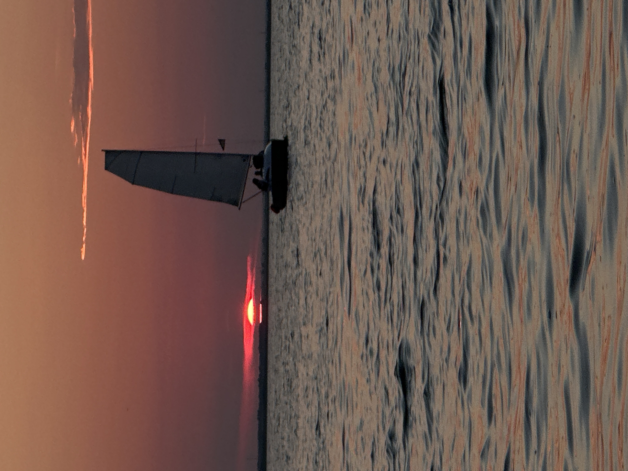 Sailboat and sunset over a Kokshetau lake, summer evening.