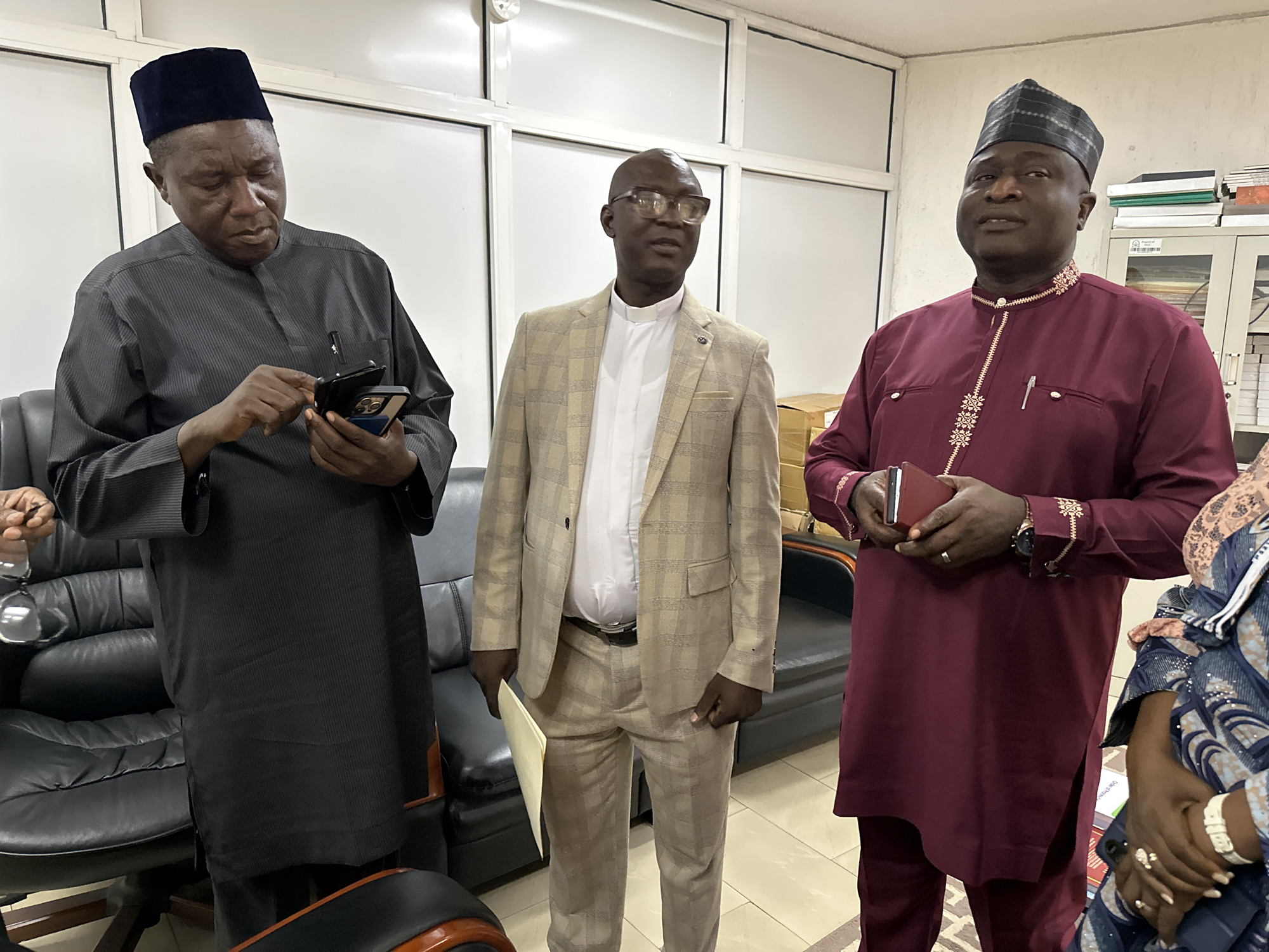 Document exchange and discussions at an Abuja office meeting