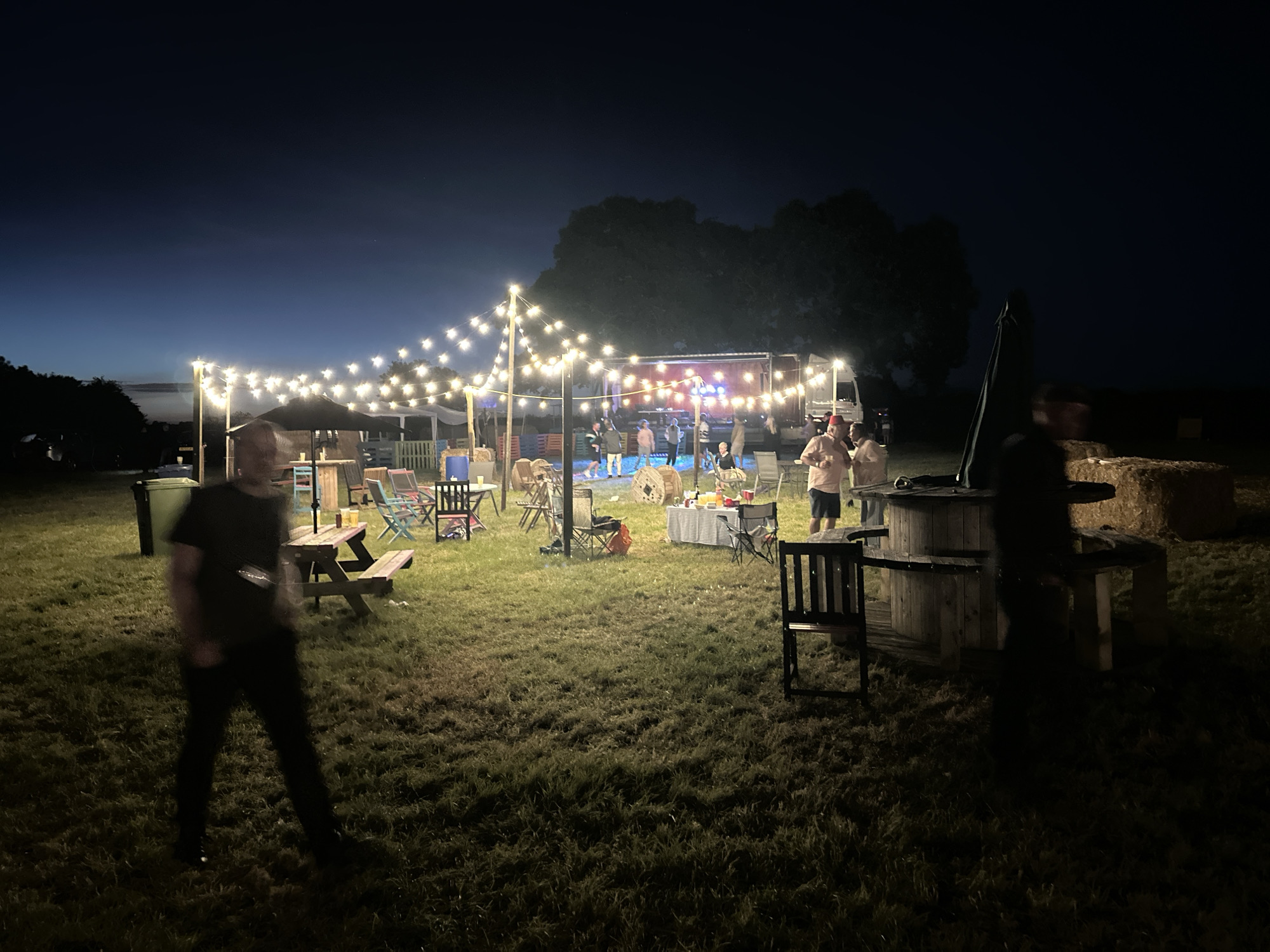Nighttime outdoor gathering with dancing in Tewkesbury