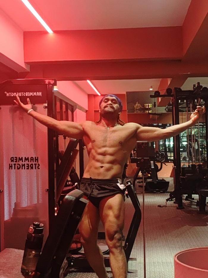 Man works out at red-lit Chongqing gym with cats present