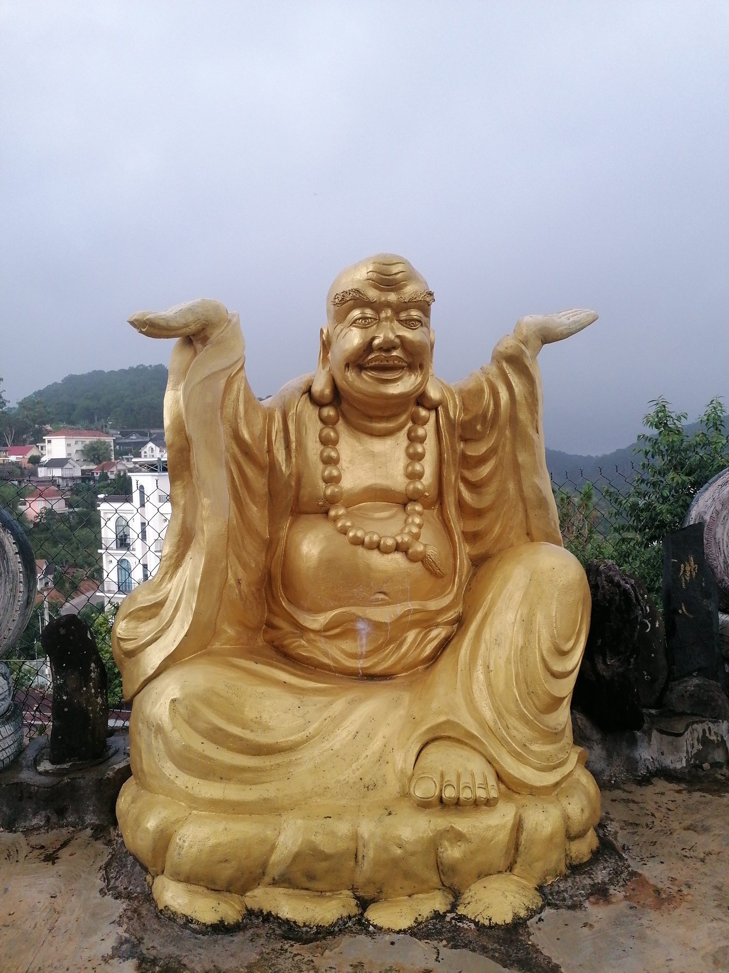 Tourist documents Buddhist temple complex in misty Da Lat