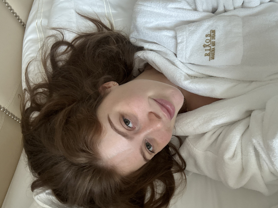 Woman in hotel robe rests in Abu Dhabi marina accommodation