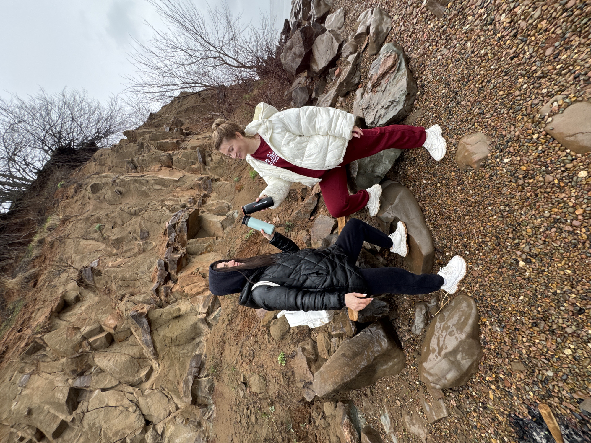 Two women explore pebble beach in Kostovaty, Russia