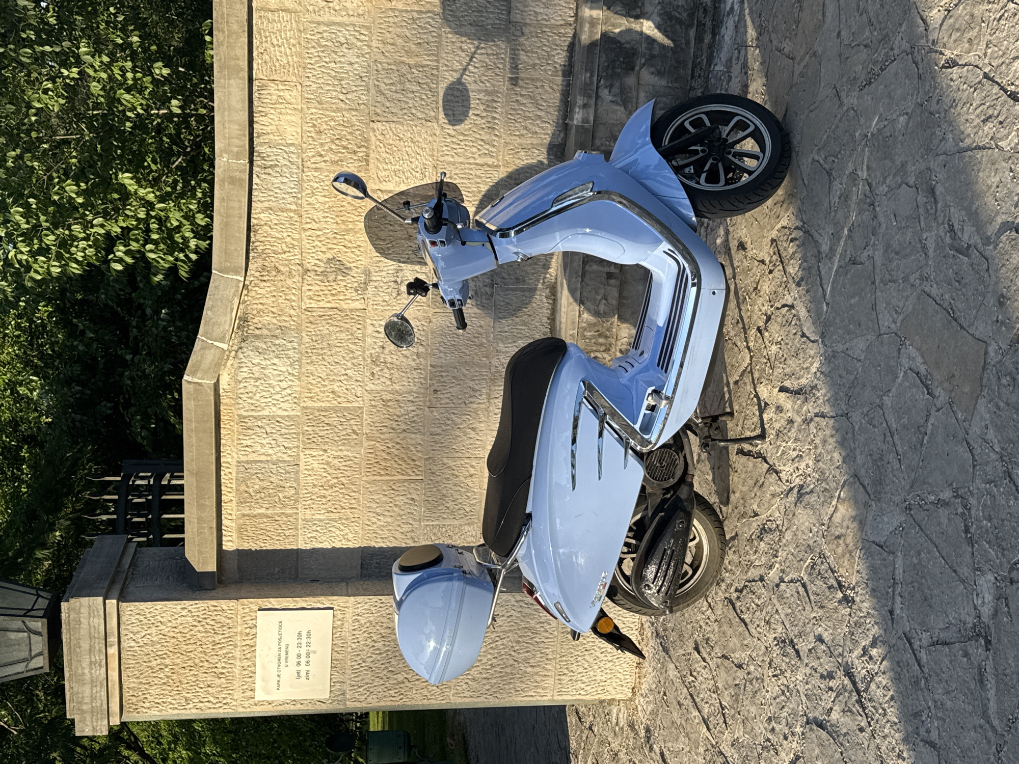 Blue scooter parked near park entrance in Podgorica