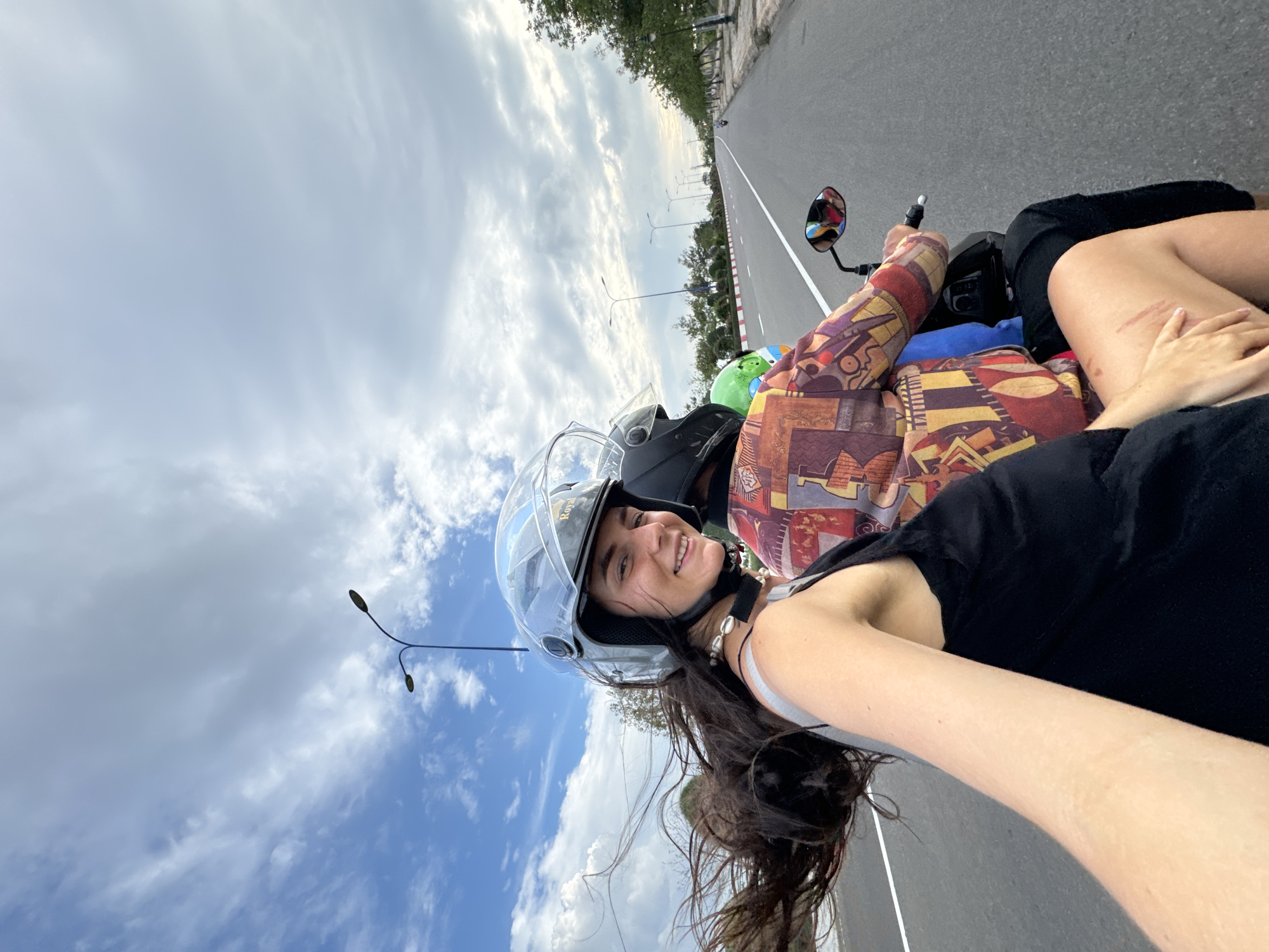 Woman takes selfie while riding motorcycle passenger in Vietnam