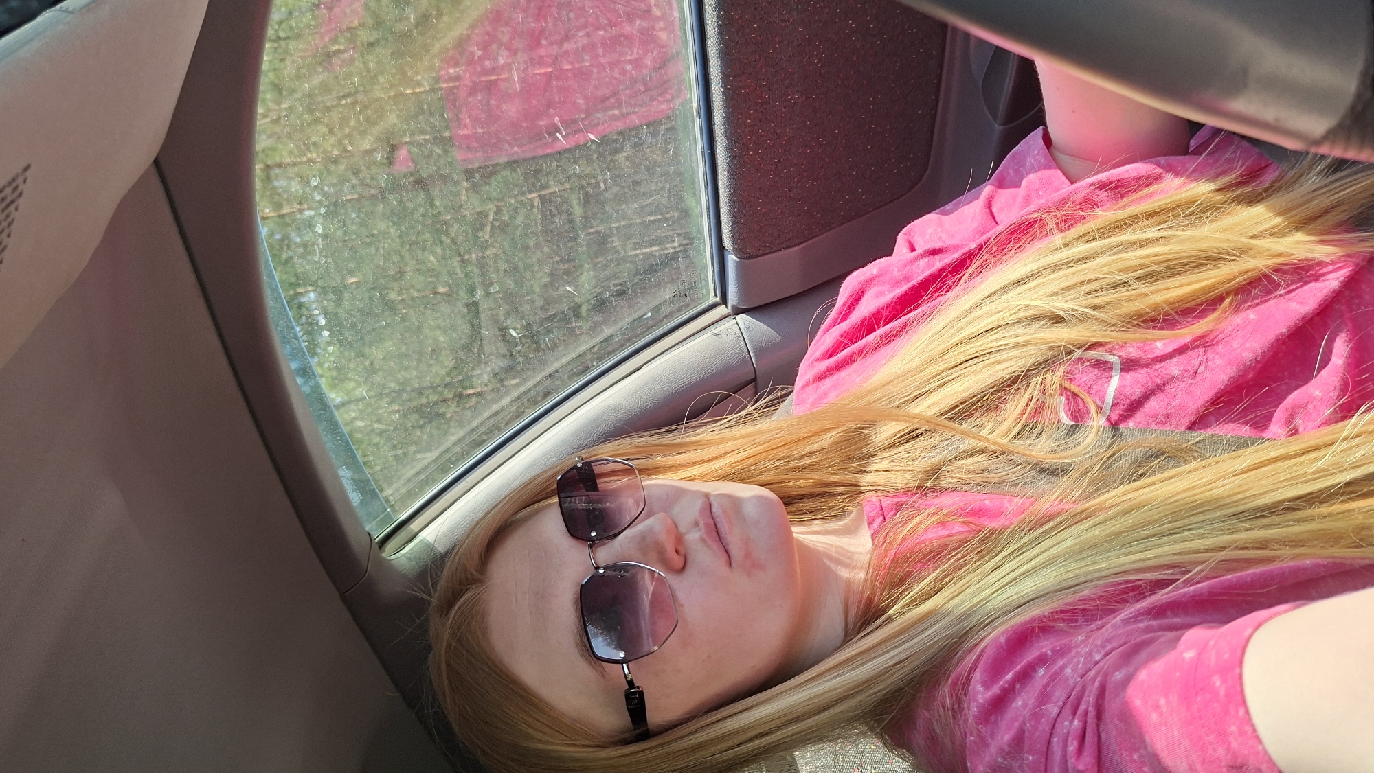 Person in pink shirt resting inside vehicle in Chaikovsky