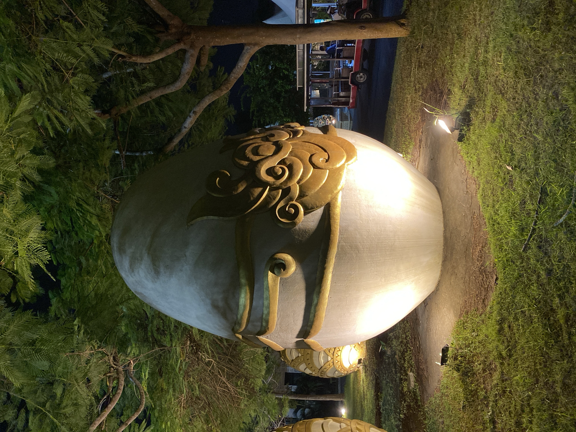Nighttime resort grounds in Kuta Selatan with ornate egg sculptures and trolleys