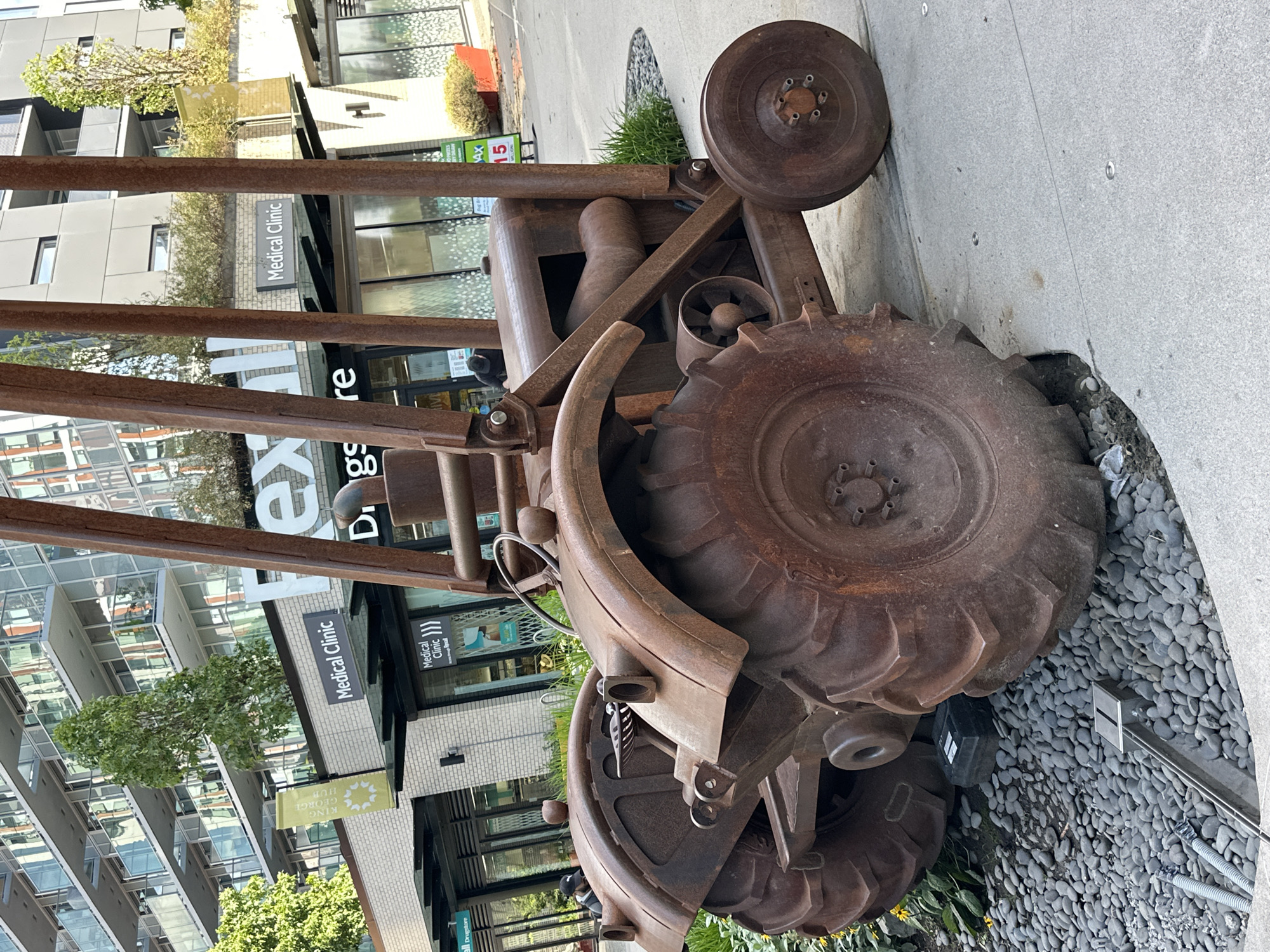 Rusty tractor sculpture and urban architecture in Surrey, BC