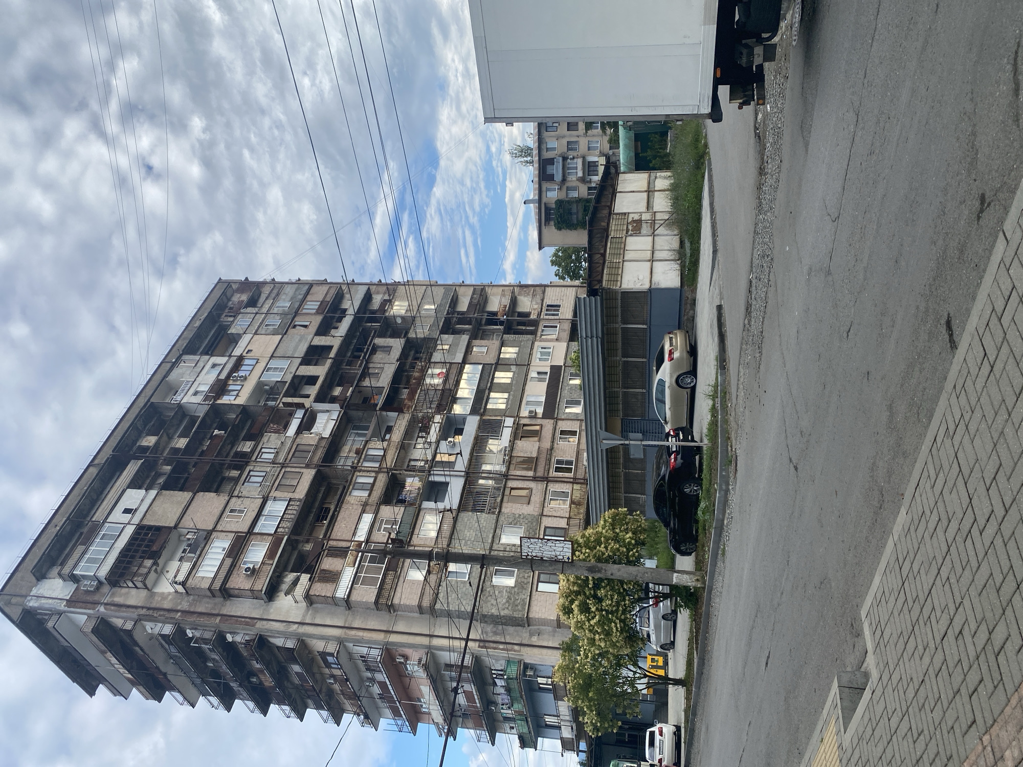 Quiet urban block, cloudy morning, apartment complex and street life