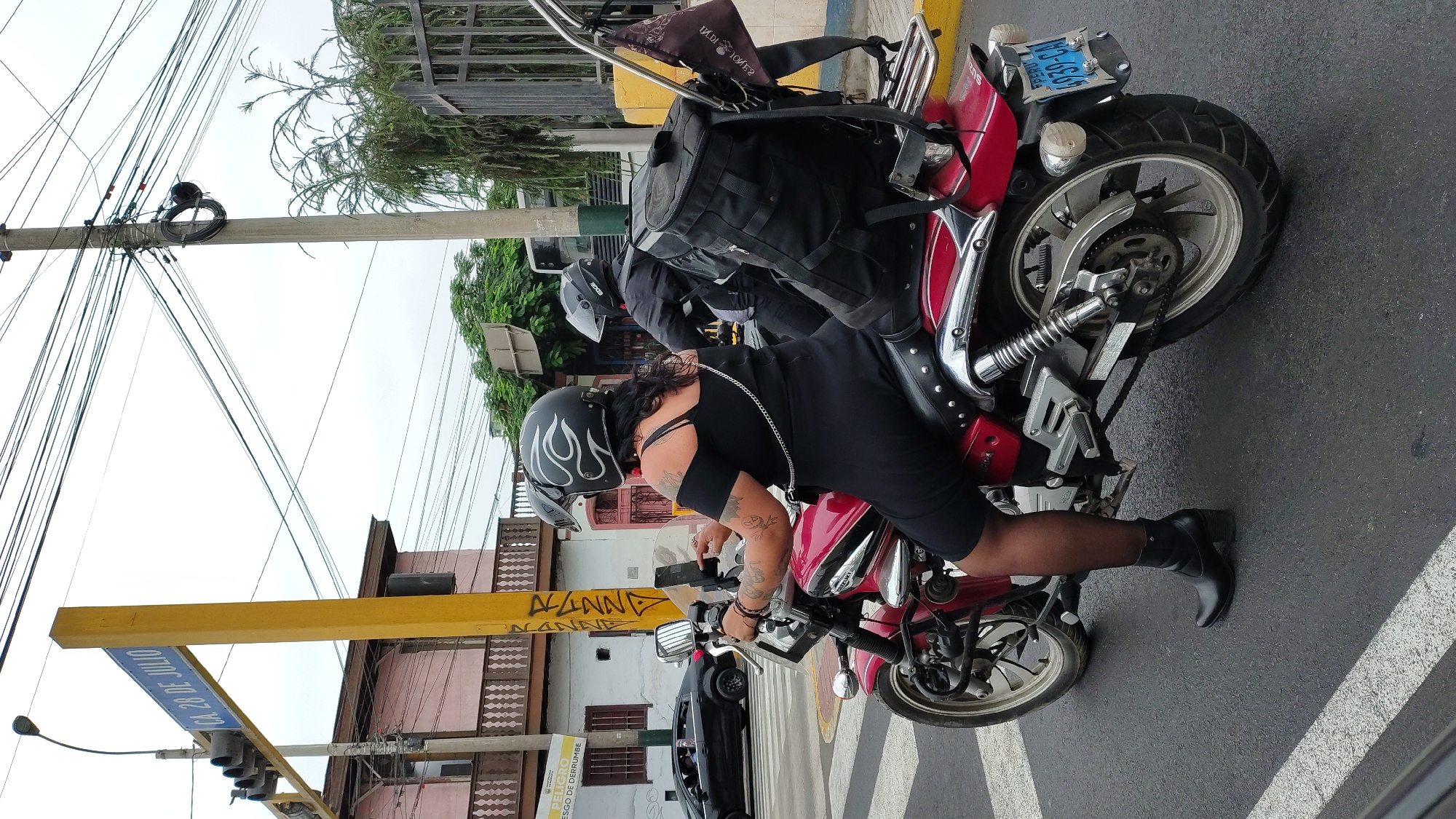 Woman on red motorcycle spotted at Barranco intersection