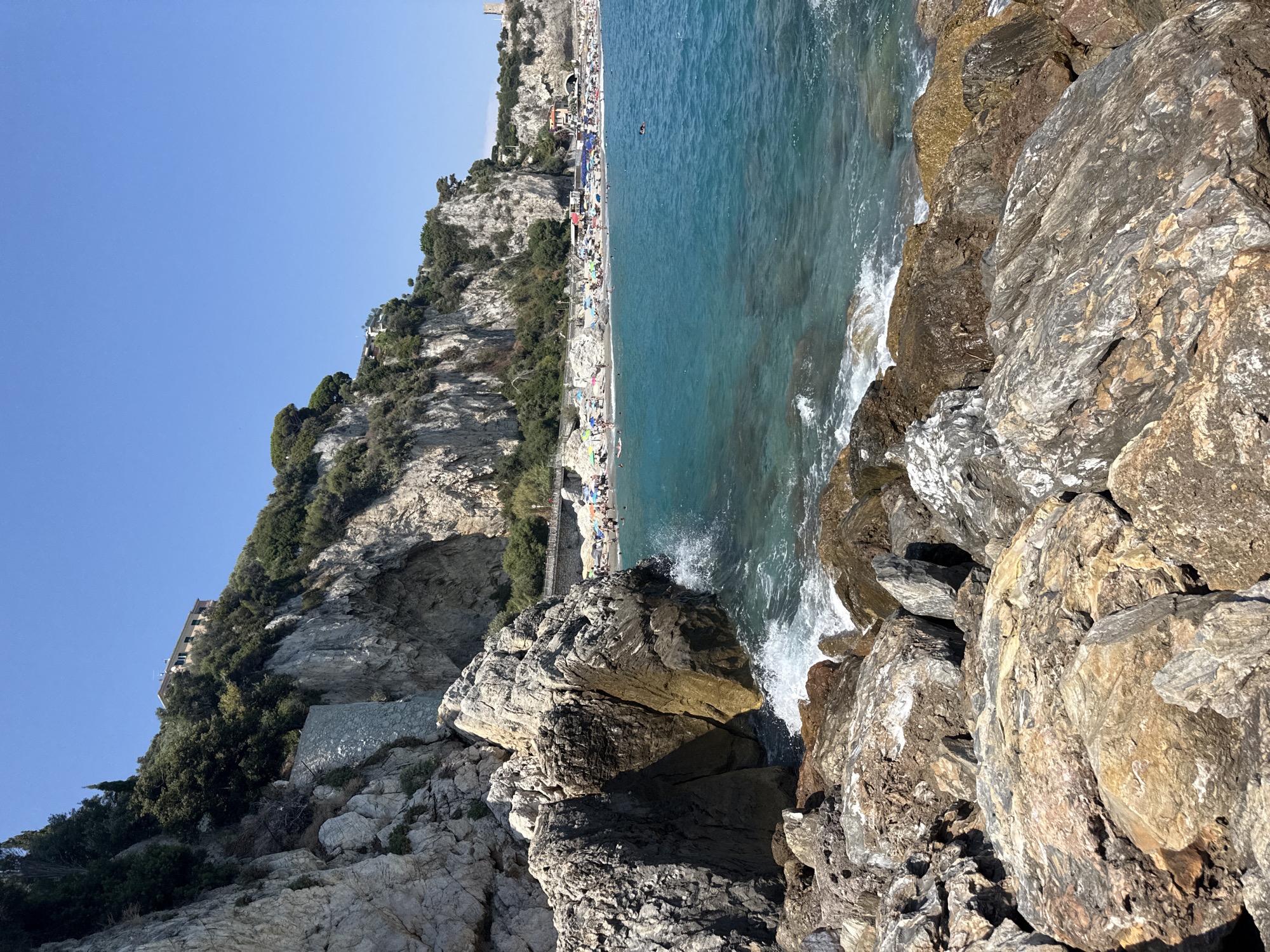 Busy summer day on Finale Ligure's pebble beach