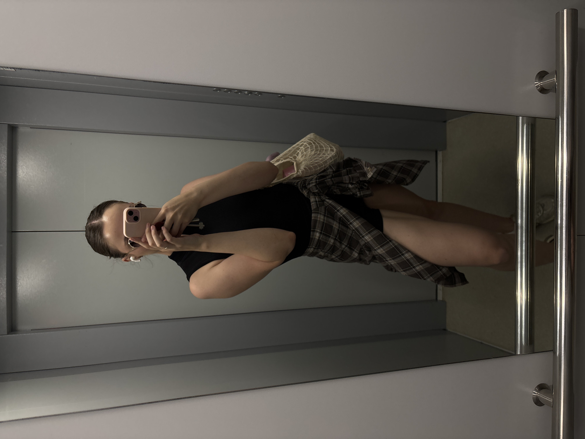 Elevator mirror selfie, low angle, full-body reflection.