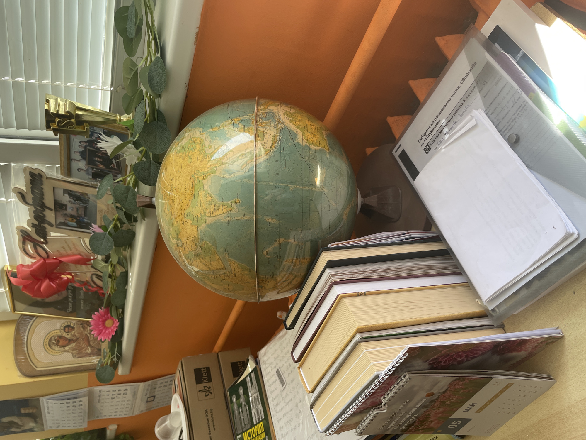 Person documents indoor space with vintage globe and wooden floors