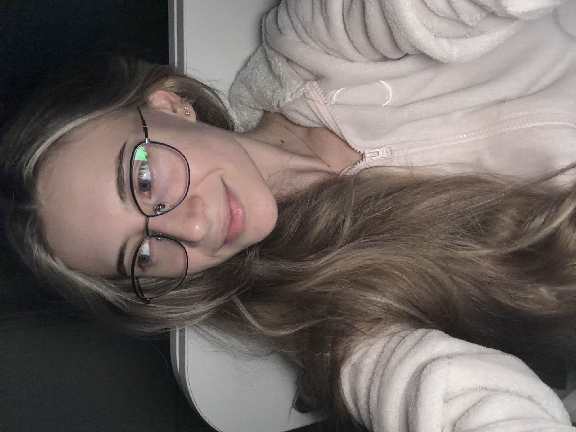 Young woman takes playful selfies in pink onesie