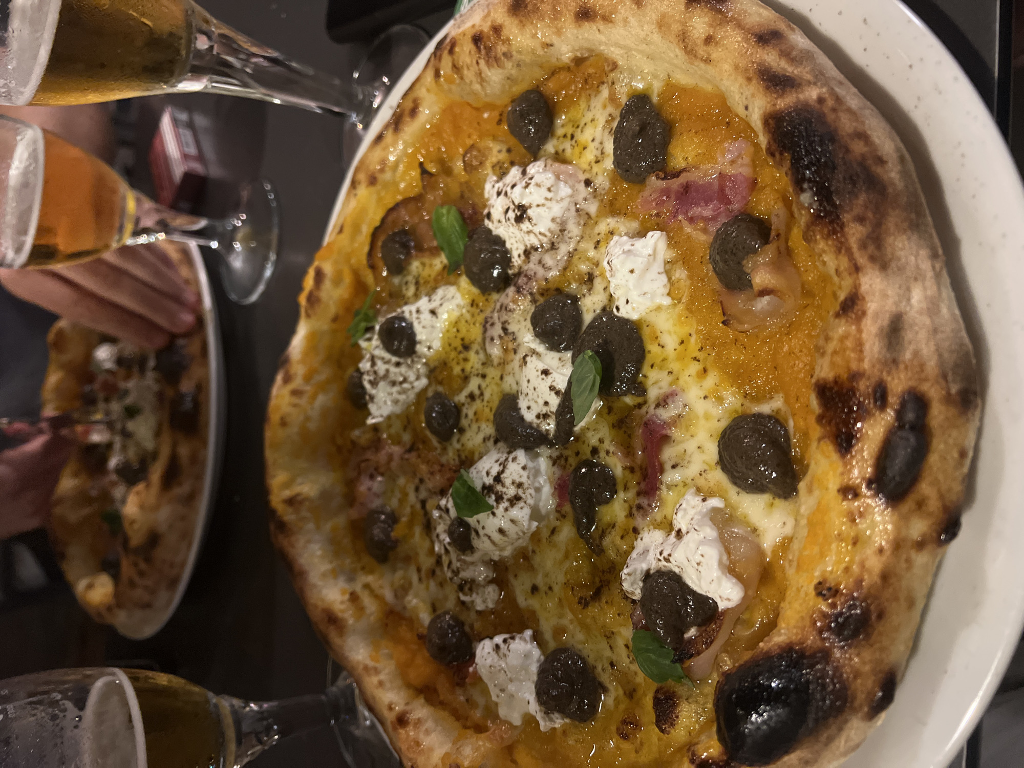Burnt-crust pizza served with beer in València restaurant