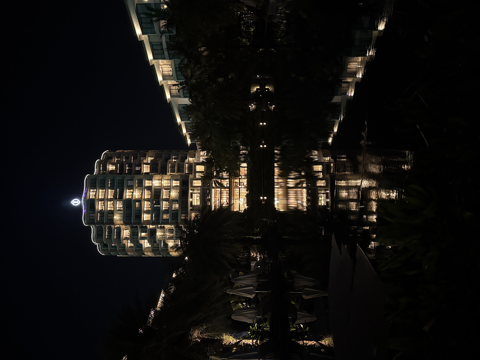 Illuminated buildings reflected in water captured in Phú Quốc