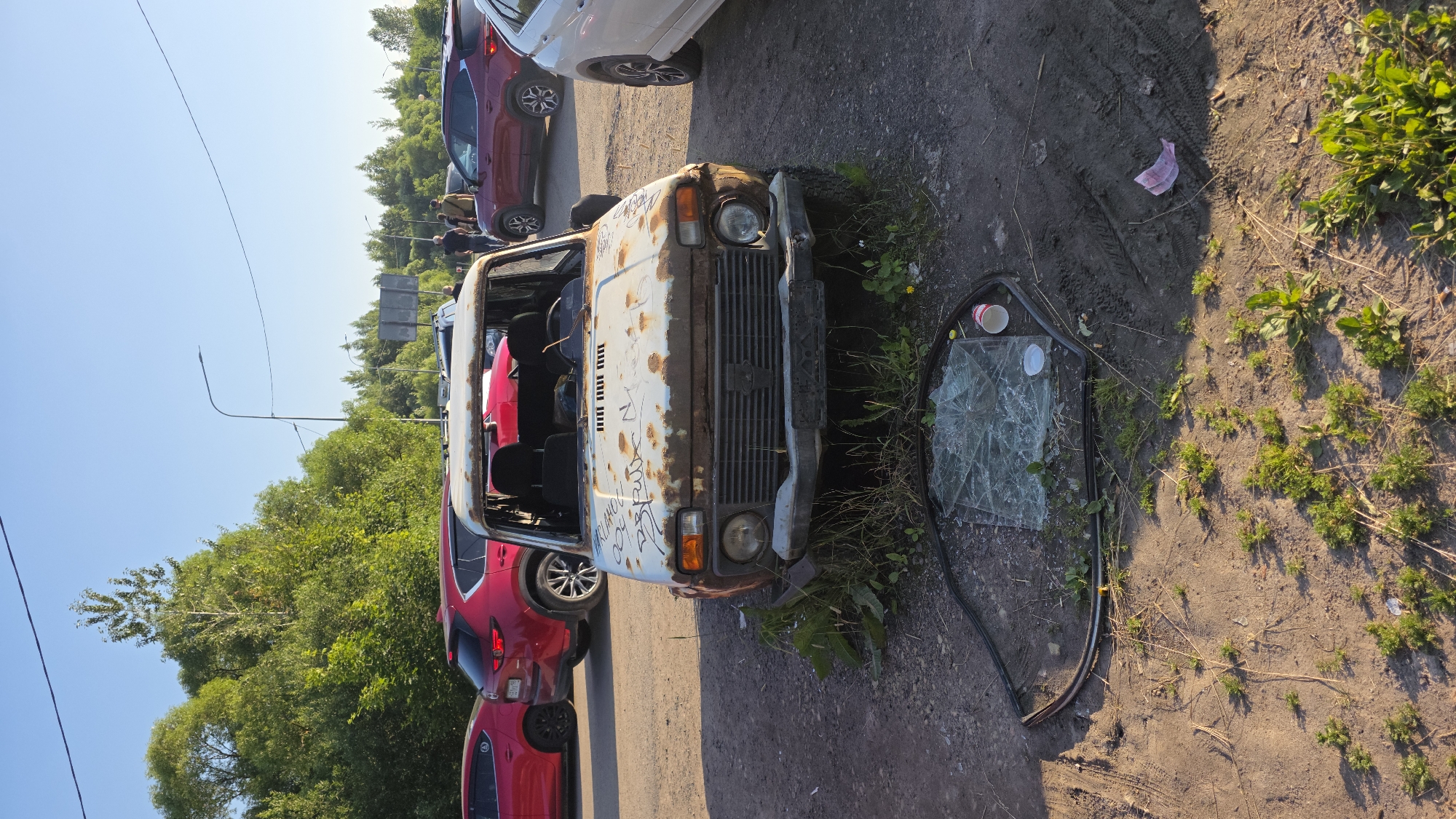 Rusted vehicles and ornate architecture at a lakeside setting