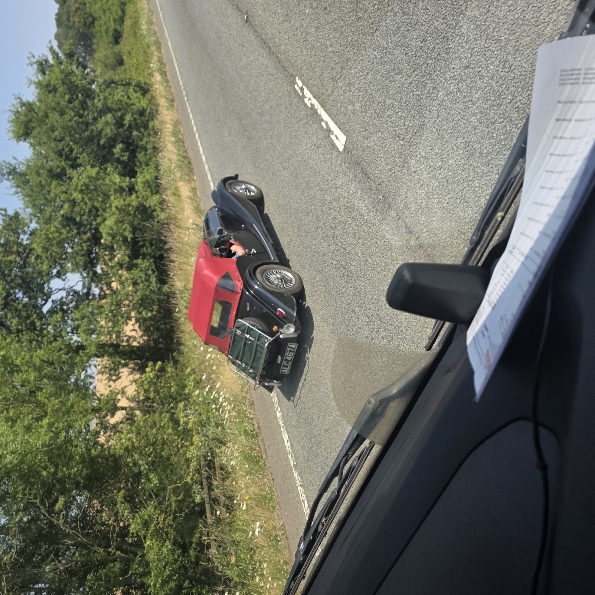 Classic black convertible with luggage rack rolling through Naseby