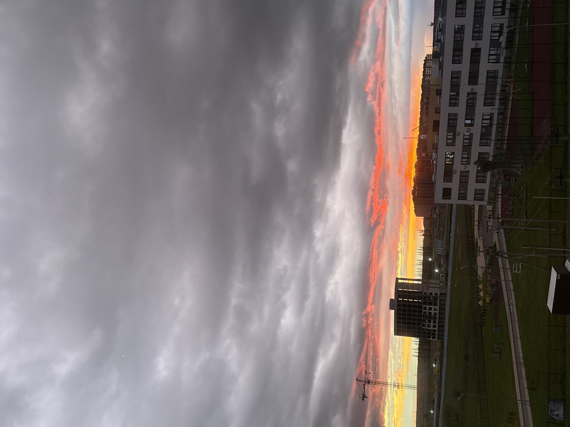 Dramatic sunset illuminates city skyline with vibrant orange clouds