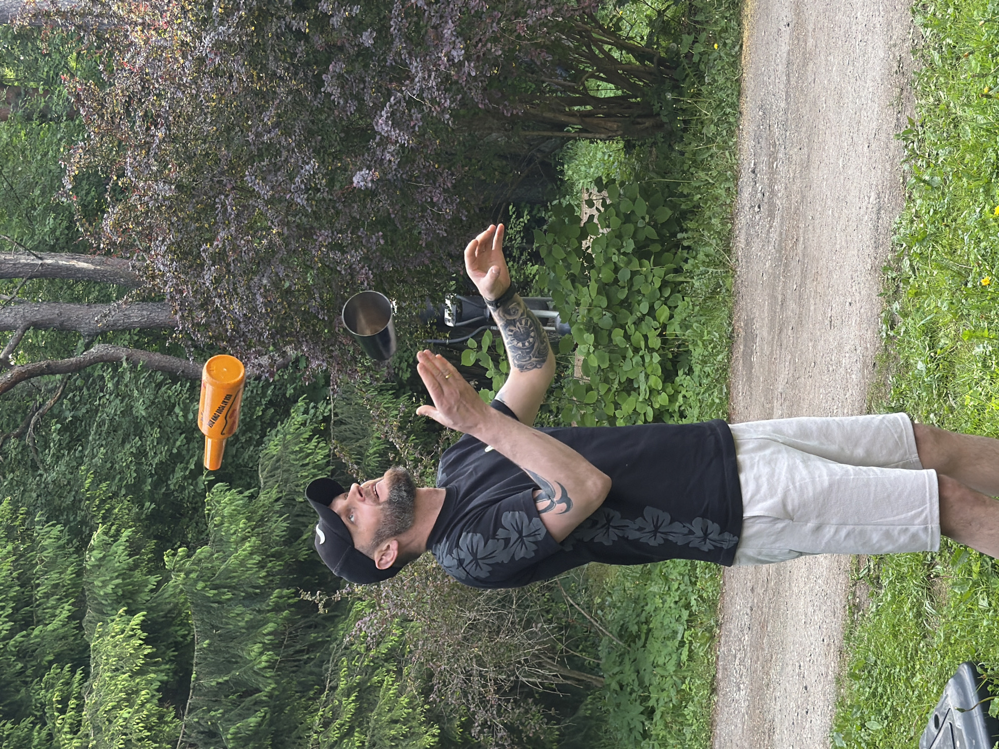 Man juggles bottle and cup in Tallinn park