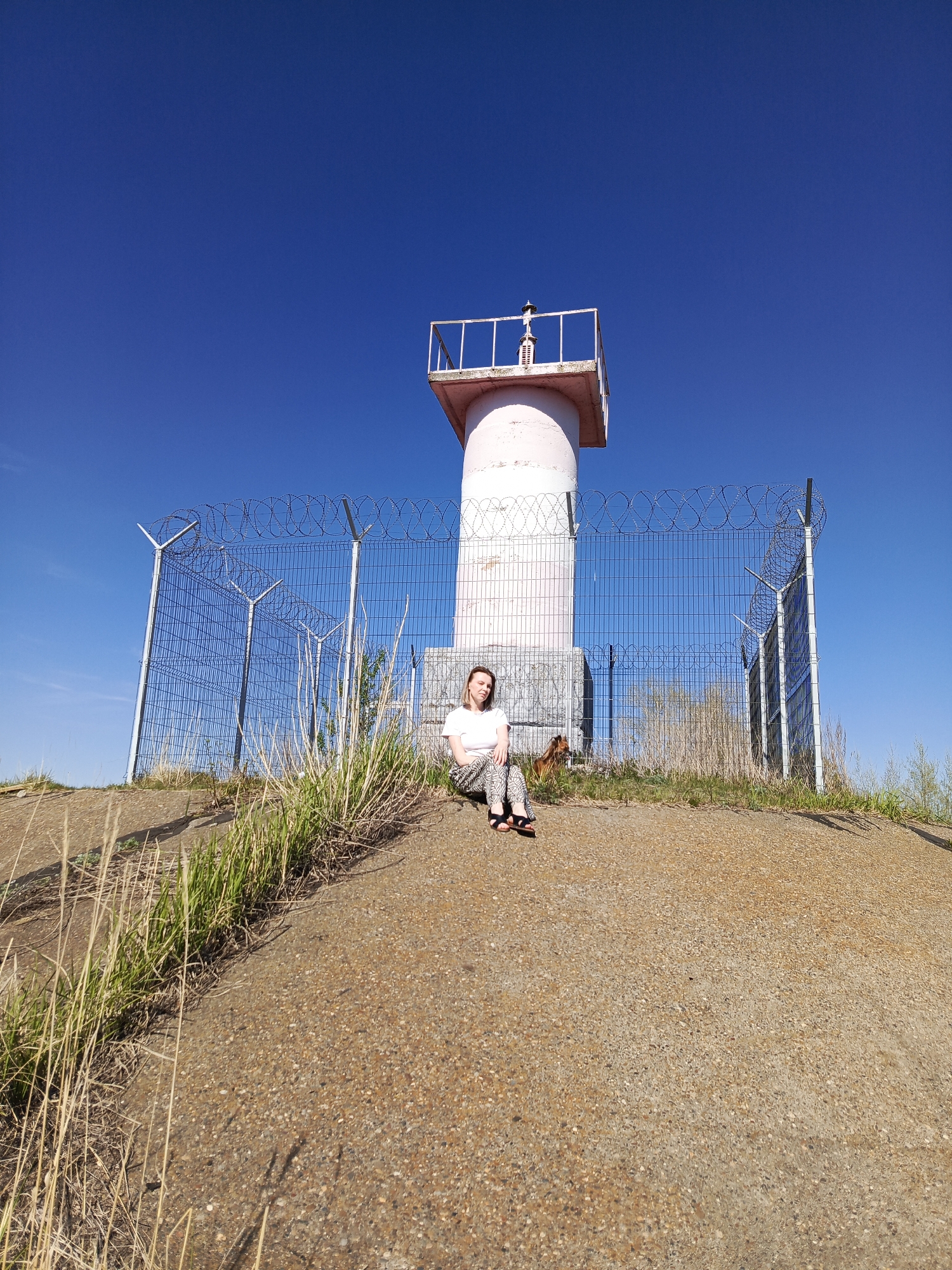 Visitors document riverside lighthouse area in Chaikovsky, Russia