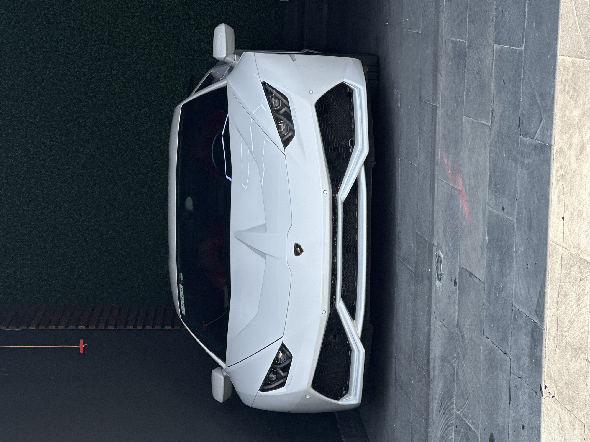 White Lamborghini displayed near modern buildings in Mexican town