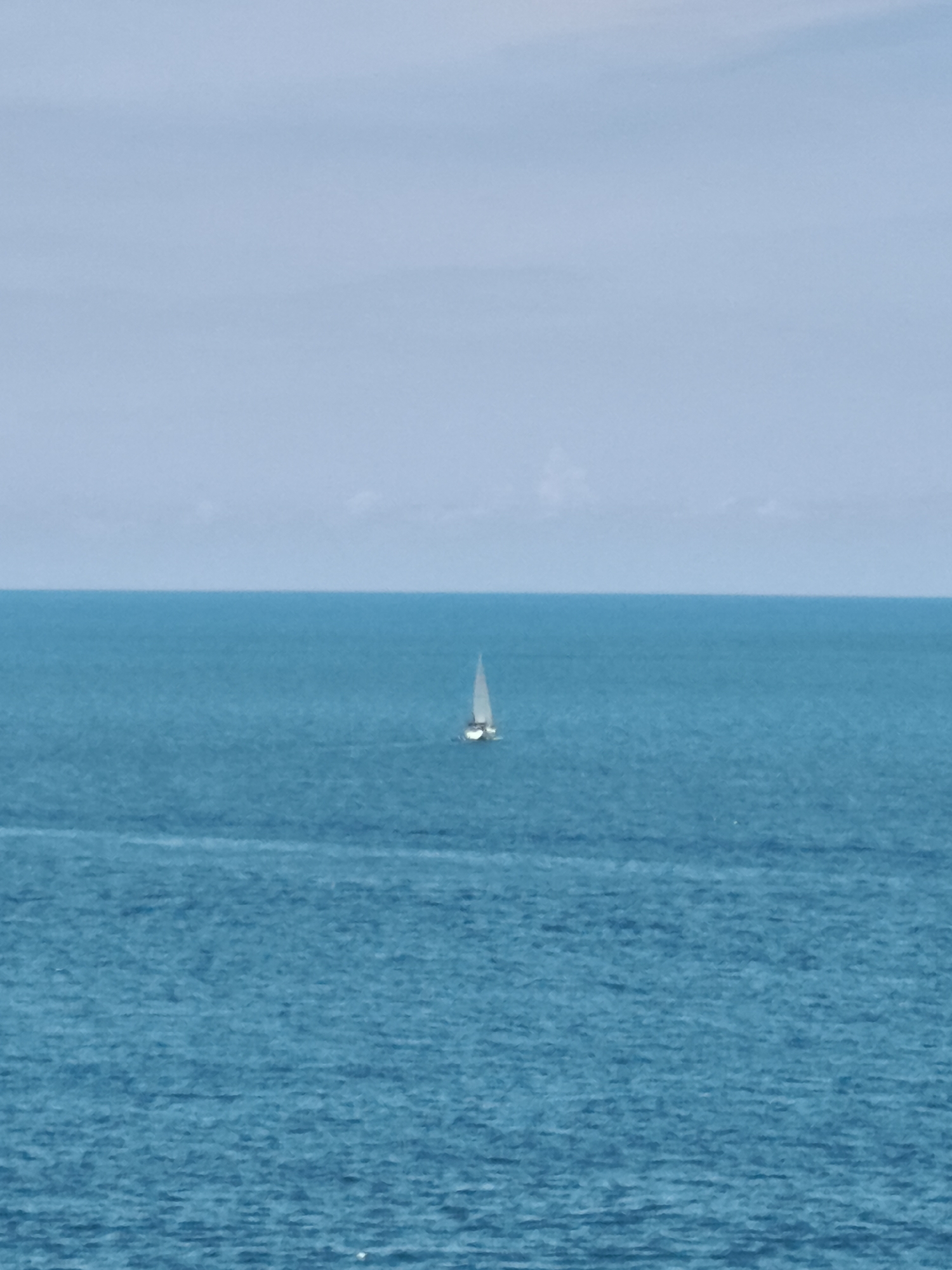 Morning coastal snapshot: Ko Samui roads, water, and a parked motorcycle