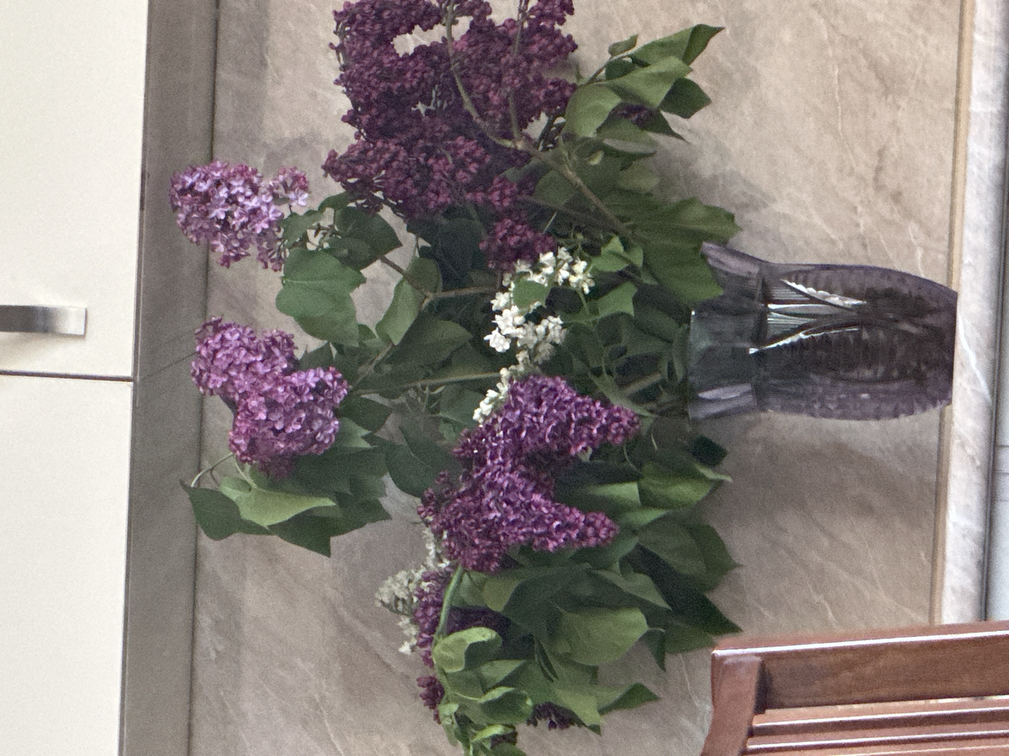 Indoor scene captures lilac bouquet and framed wall artwork