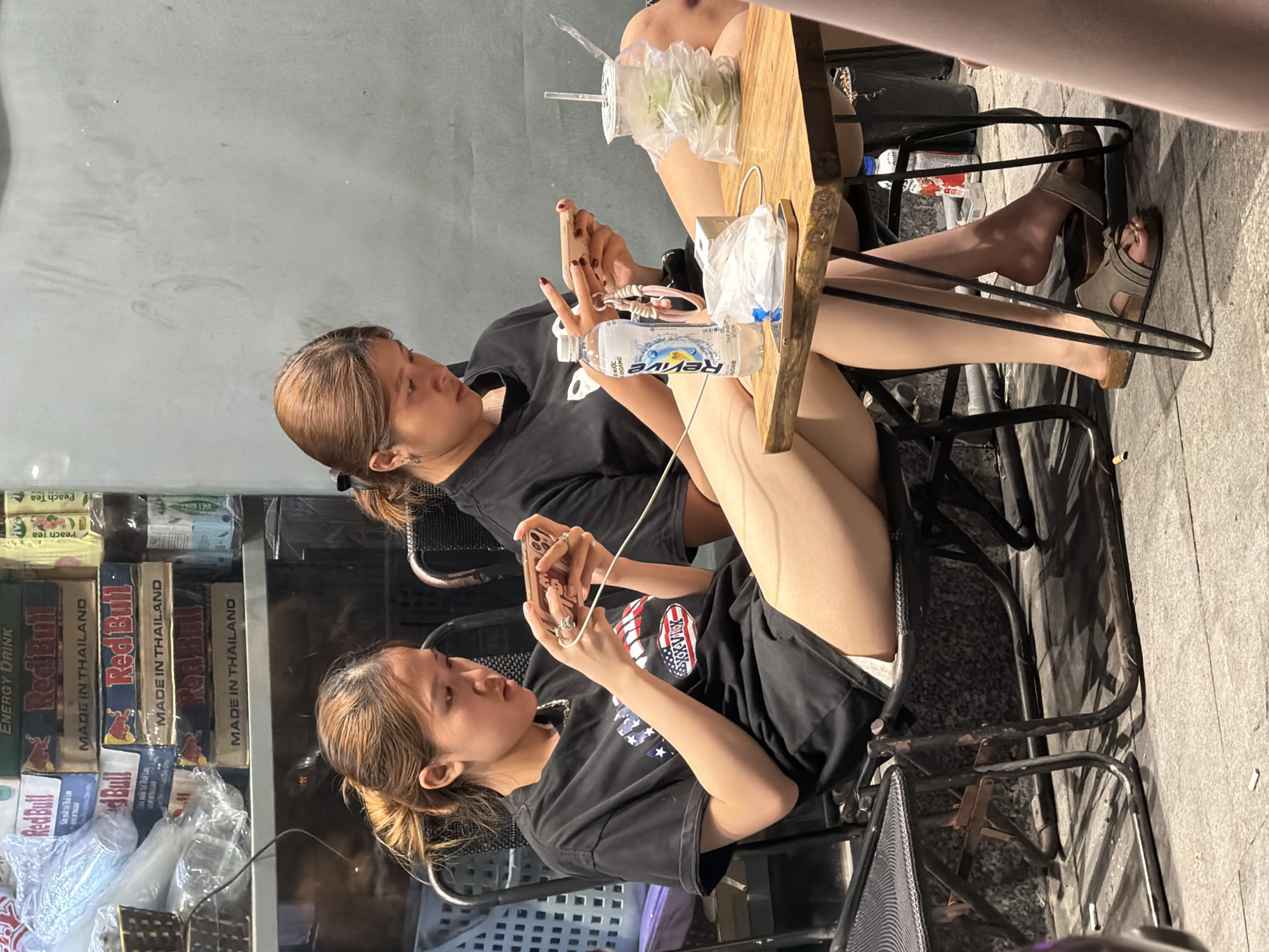 Two women use phones at Đà Nẵng cafe