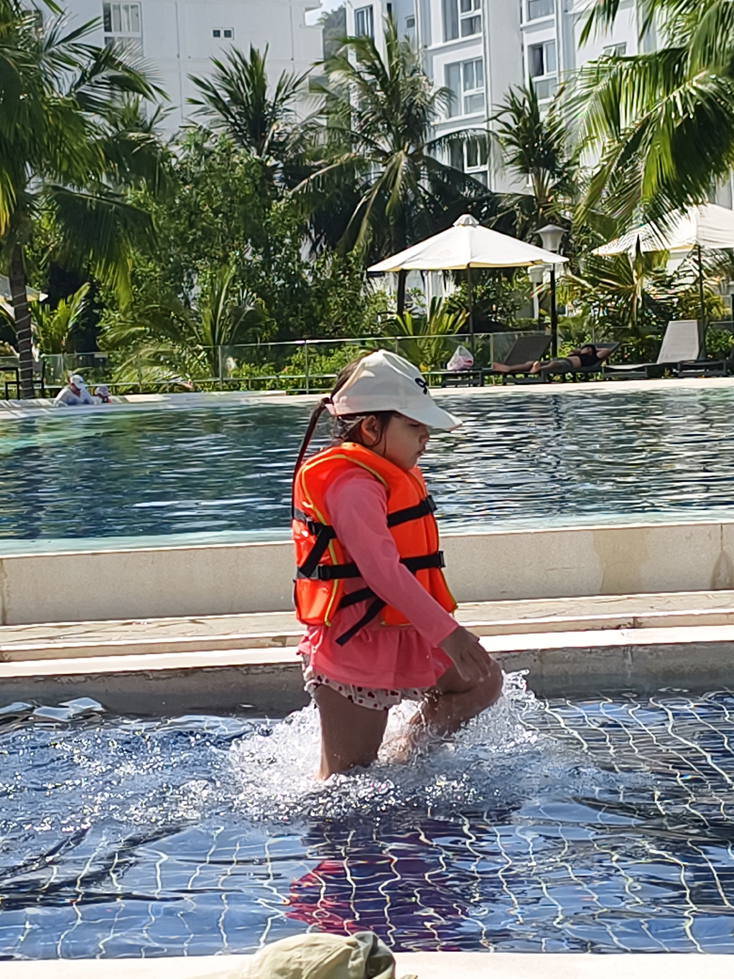 Child enters resort pool in Bac Nha Trang Ward