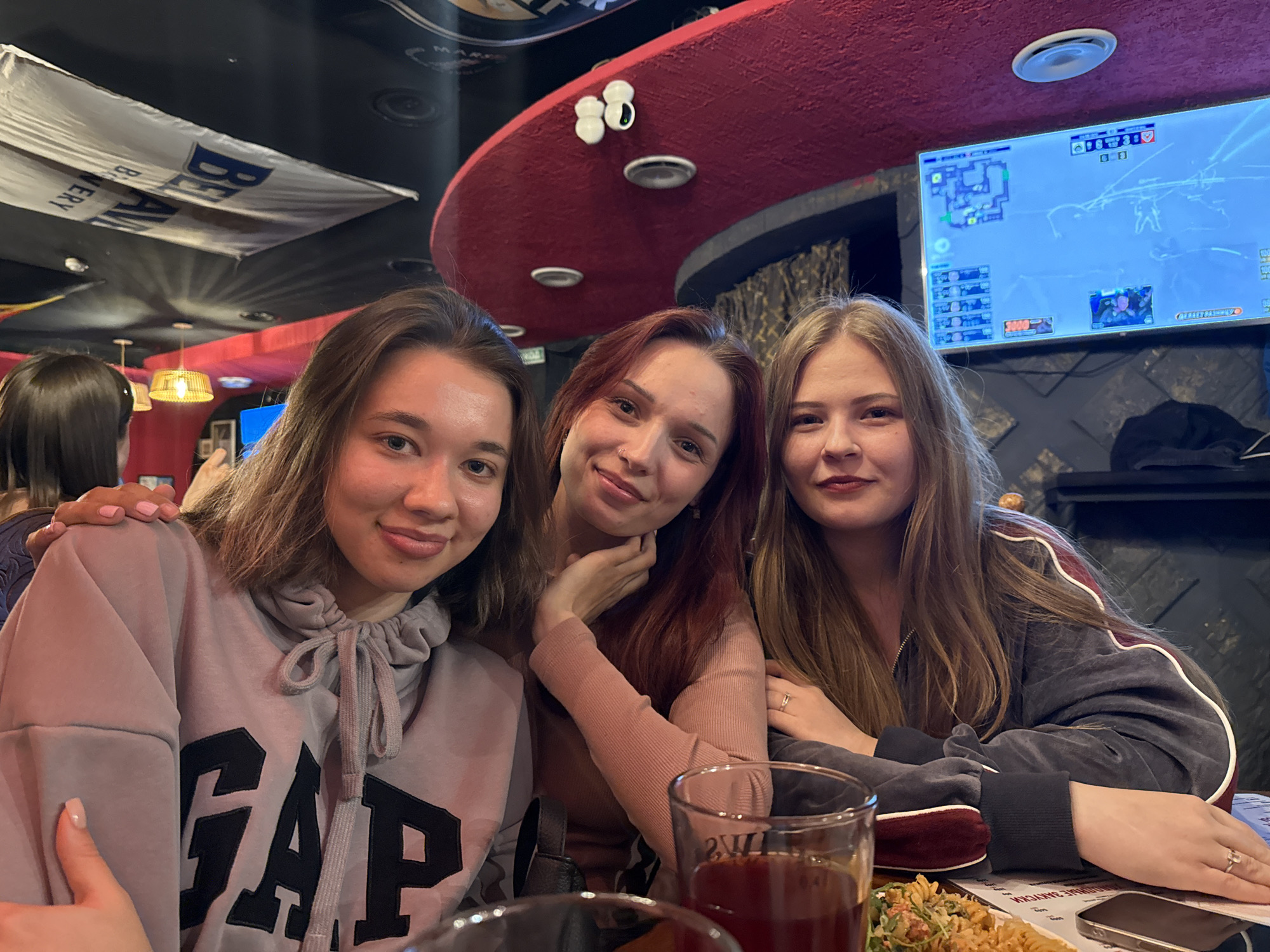 Three women socialize over drinks at Chaikovsky bar
