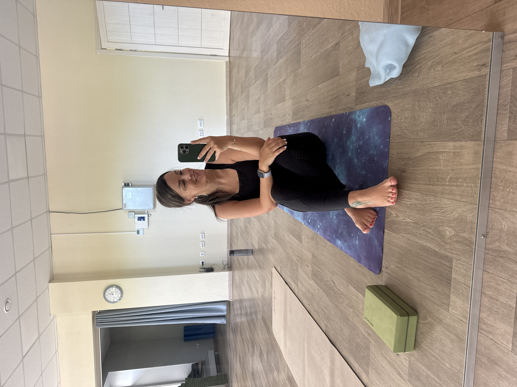 Woman takes mirror selfie during yoga session in Krasnoyarsk studio