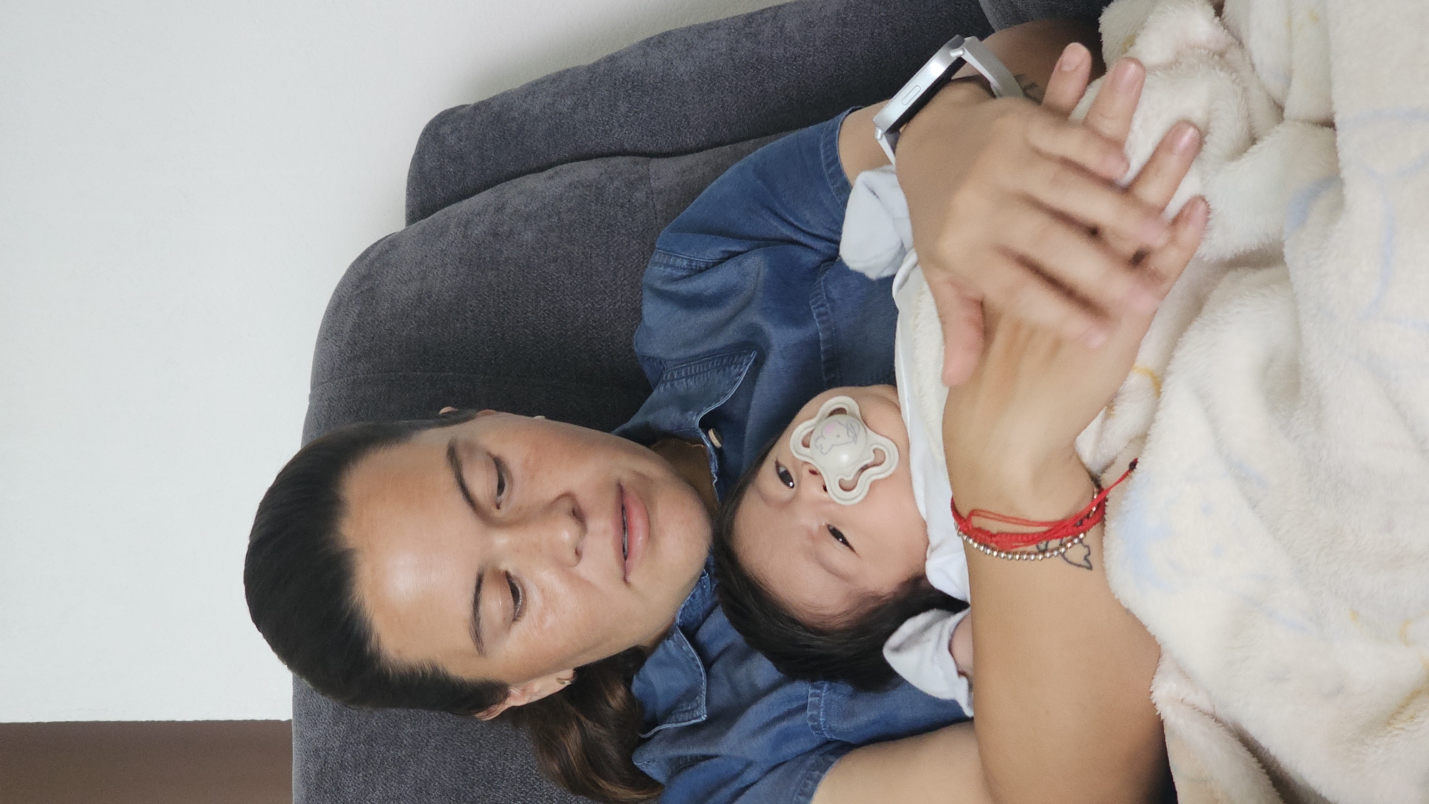 Parent cradles baby on couch in Mexican town