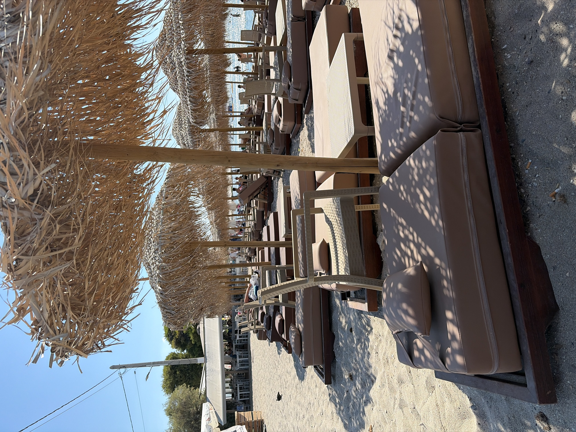 Thatched umbrellas and loungers line a quiet resort beach