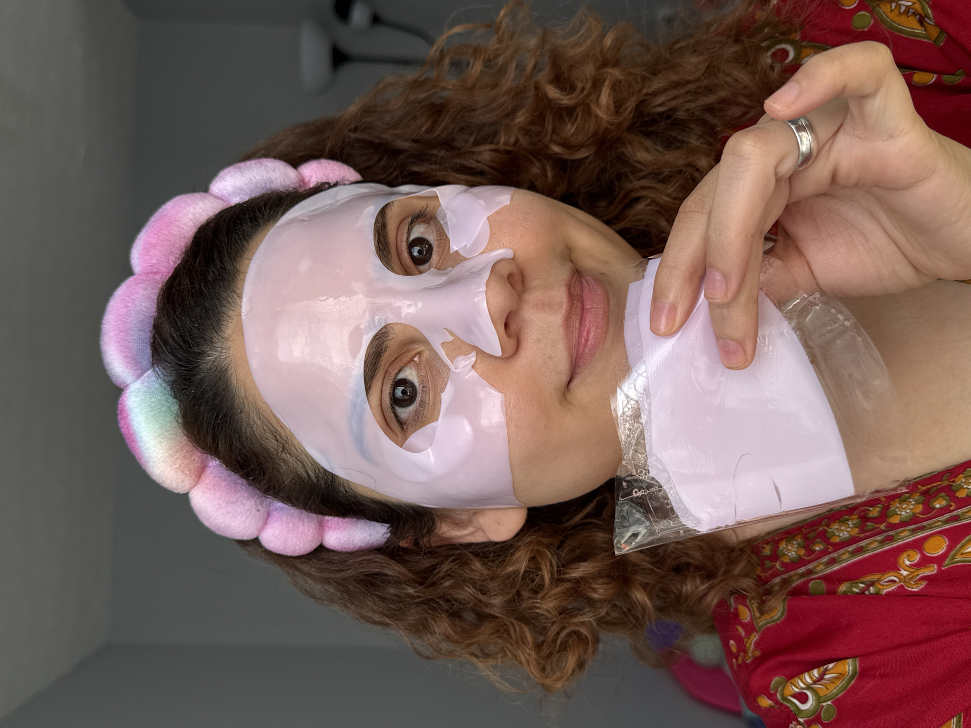 Woman applies pink face mask during afternoon skincare routine