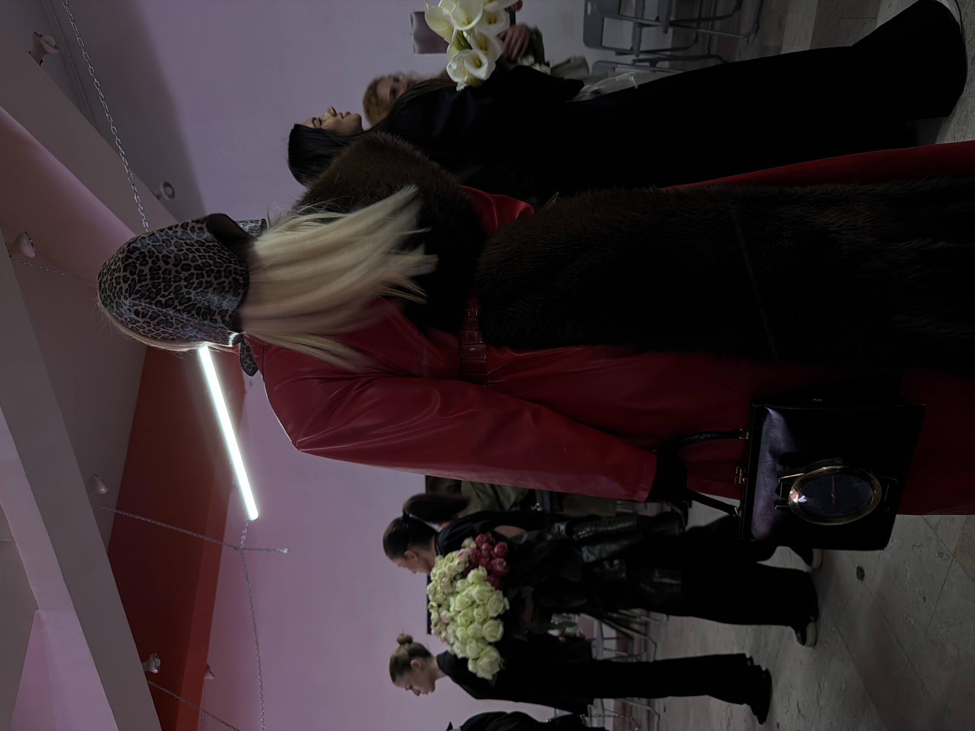 Fashion show features model in leopard headscarf, red coat