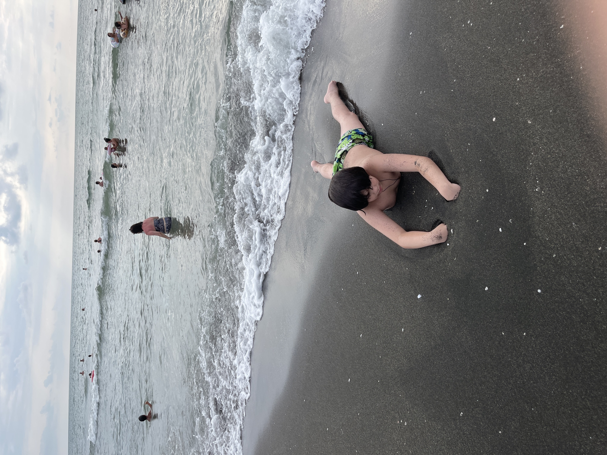 Crowded summer afternoon on Ureki's black sand beach