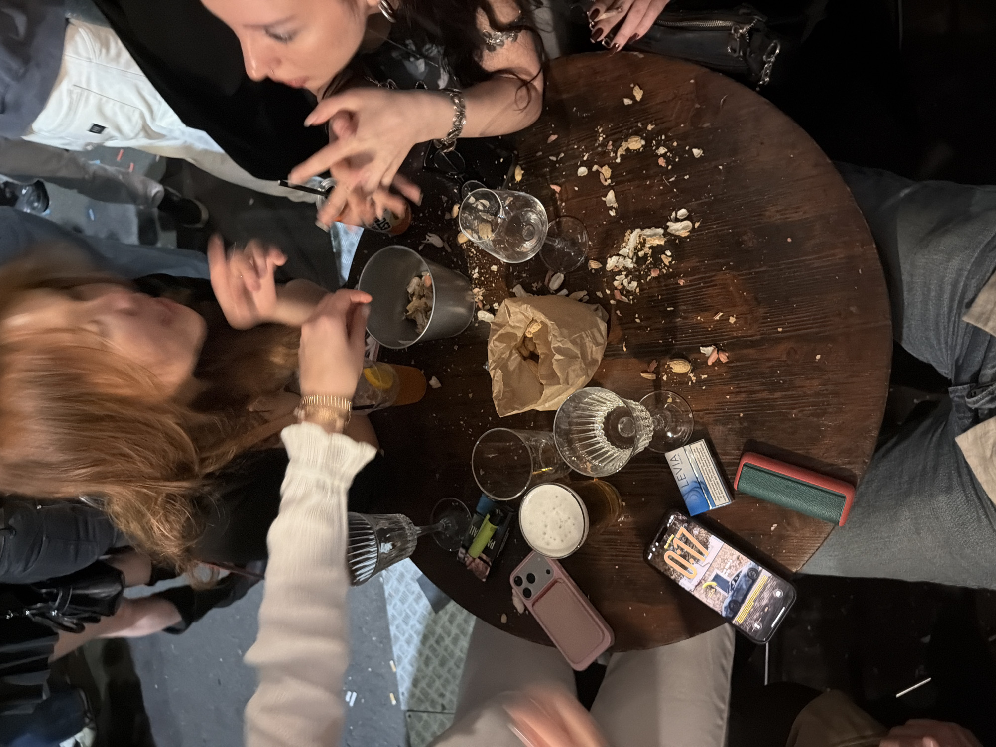 Group gathers at peanut-shell covered table in Milan bar